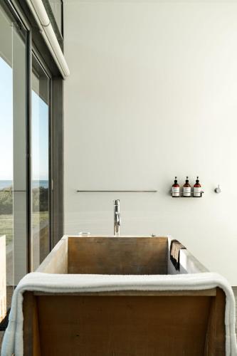 a kitchen with a sink and a large window at Avalon Coastal Retreat in Swansea