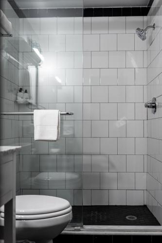 a white tiled bathroom with a toilet and a shower at The Sobro Guest House by AvantStay in Nashville