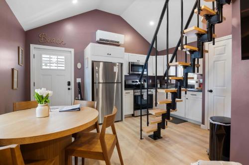 a kitchen with a table and a spiral staircase at Coastal Breeze Cottage - Tiny Home at Hampton Beach in Hampton