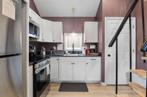 a kitchen with white cabinets and a sink at Coastal Breeze Cottage - Tiny Home at Hampton Beach in Hampton