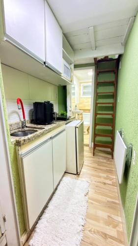 a small kitchen with a sink and a dishwasher at Microcasa compacta in Volta Redonda