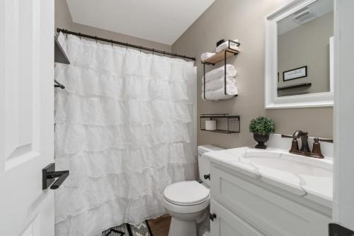 a white bathroom with a sink and a toilet at Lakeside Lodge on Bluegill- Arcade, Dock, FirePit in Eatonton