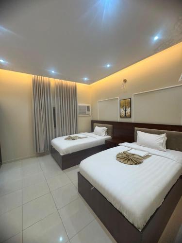a hotel room with two beds in a room at شقق خزامى الباحة in Al Baha