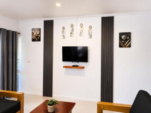 a living room with a tv on a white wall at The Beloved Corner in Nausori