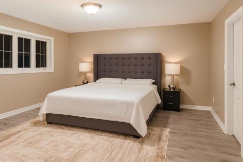a bedroom with a large white bed and two lamps at Spacious Brampton 4BR Upper Home in Brampton