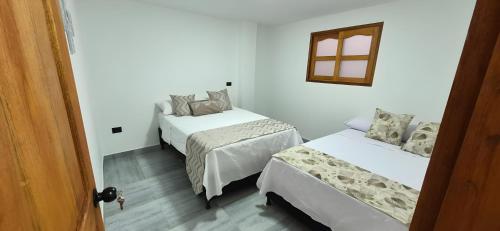 a room with two beds and a window at Portón del Río Jericó in Jericó