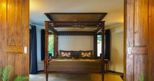 a bedroom with a canopy bed in a room at Reflections On Rarotonga in Rarotonga