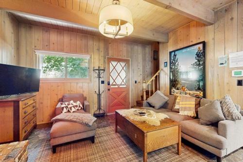 a living room with a couch and a tv at Wooded Comfort in Lake Arrowhead