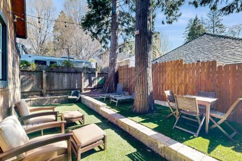 a backyard with chairs and a table and a fence at Heliotrope Hideaway in Lake Arrowhead