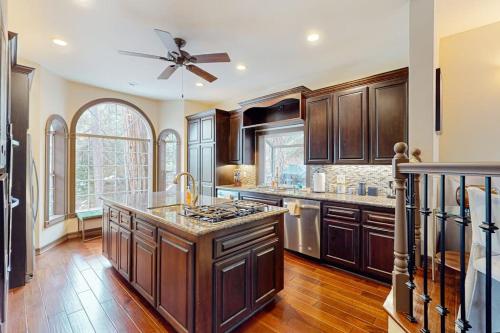 a kitchen with wooden cabinets and a ceiling fan at The Chateau in Lake Arrowhead