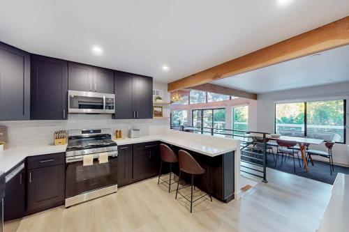 a kitchen with black cabinets and white counter tops at The Snow White in Lake Arrowhead