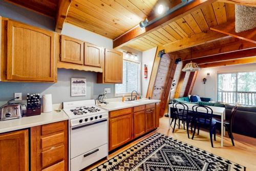 a kitchen with a stove and a dining room at Hidden Wonder in Crestline