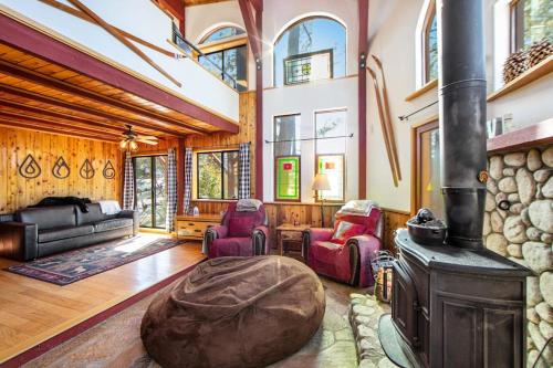 a living room with a stone fireplace and chairs at The Valley's Cabin in Green Valley Lake