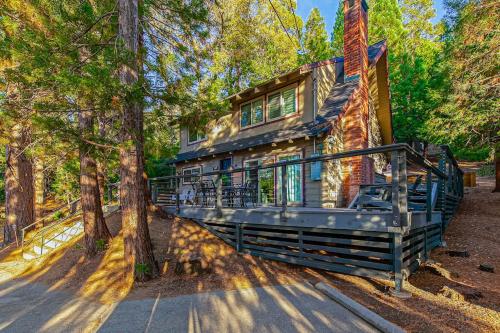 a home with a wrap around porch in the woods at Serene Cabin in Lake Arrowhead