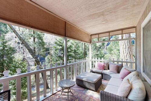 a screened in porch with a couch and chairs at The Cottage in Lake Arrowhead