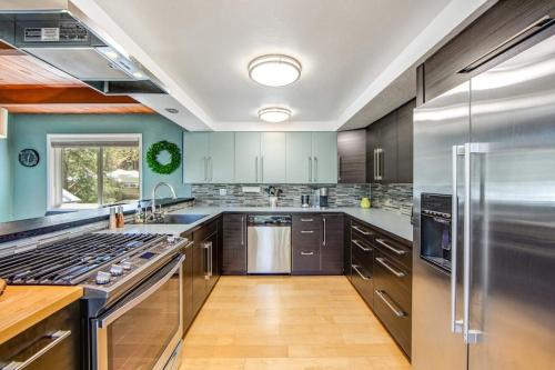 a large kitchen with stainless steel appliances and wood floors at Timber Top Retreat in Lake Arrowhead