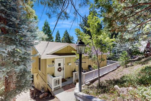 a yellow house with a porch and a street light at Treetop Cottage in Running Springs