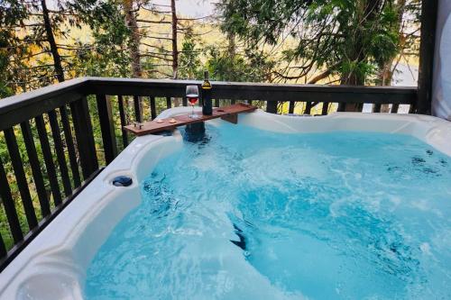 a hot tub on a balcony with a bottle of wine at Lakeside Serenity in Crestline