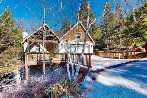 a wooden house with a deck on a driveway at Arrowhead Haven in Lake Arrowhead