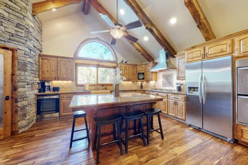 a kitchen with wooden cabinets and a stone wall at Arrowhead Haven in Lake Arrowhead