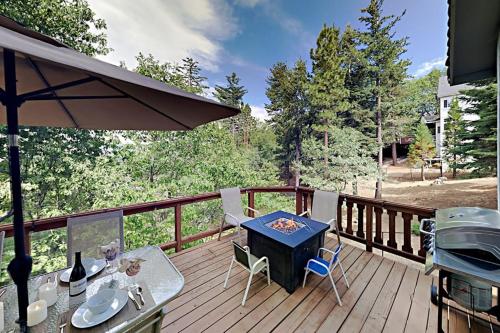 a deck with a grill and a table and chairs at Emerald Oasis in Lake Arrowhead