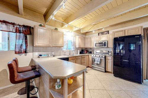 a kitchen with wooden cabinets and a black refrigerator at Treelands Lodge in Crestline