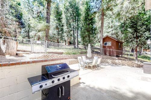 a backyard with a grill and a table with chairs at Treelands Lodge in Crestline