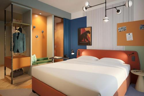 a bedroom with a large bed and a suit on display at Me and All Hotel Leipzig, by Hyatt in Leipzig