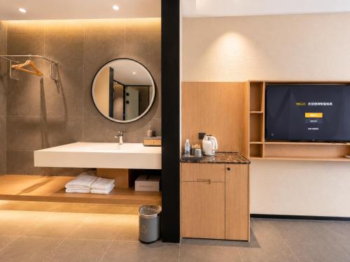a bathroom with a sink and a mirror and a tv at Clover Hotel & Spa in Phnom Penh