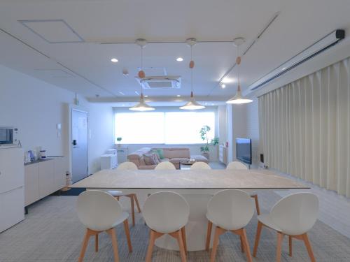 a kitchen and living room with a table and chairs at INOVE VILLA OSAKA -120m2 , 7 Double Beds , 2 BR , 2 Bath , Easy Access to Umeda , Kyoto ーPerfect for Families & Groupsー in Osaka