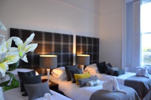 a hotel room with three beds with pillows at Edinburgh37 in Edinburgh