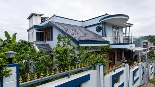 a house with blue trim and a fence at Mrinal Homestay in Ponda