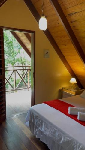 a bedroom with a bed and a large window at Chalé Suíço - Chalés Belo Monte - Sítio Belo Monte in Pacoti