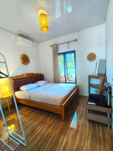 a bedroom with a bed and a television in it at Bunaken Paradise Beach Homestay in Bunaken