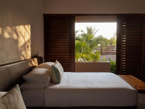 ein Schlafzimmer mit einem Bett und einem großen Fenster in der Unterkunft Lo Sereno Casa de Playa in Troncones