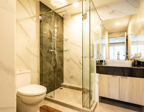 a bathroom with a shower and a toilet and a sink at Chaidee Mansion in Bangkok