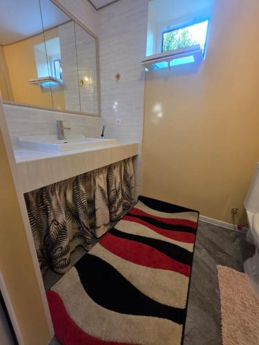 a bathroom with a sink and a mirror and a rug at Баракат in Chon-Sary-Oy
