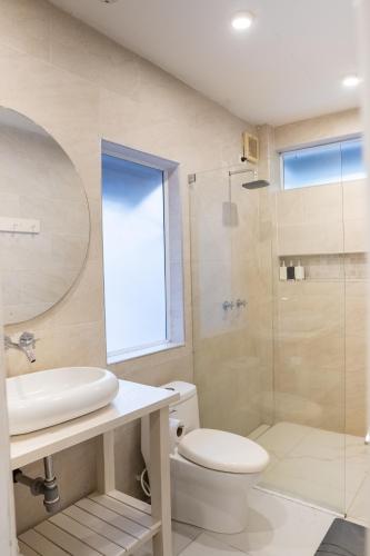 a bathroom with a toilet and a sink and a shower at Blue Mango Beach Hotel in Guachaca