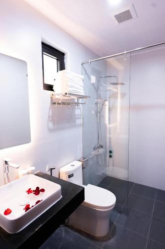 a bathroom with a toilet and a glass shower at CELINA HOTEL Ninh Bình in Ninh Binh