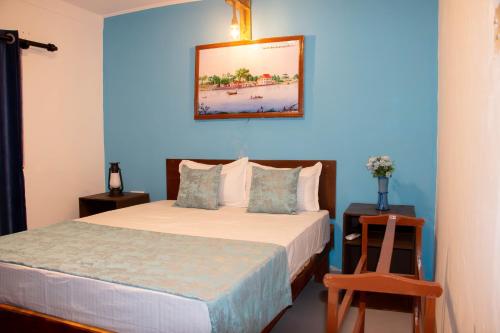 a bedroom with a bed with a blue wall at Claasz Prime Lagoon in Katunayaka