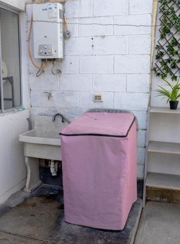 a bathroom with a sink and a pink trash can at Don Checho's House in Ica
