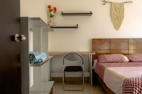 a bedroom with a bed and a desk and a chair at Don Checho's House in Ica
