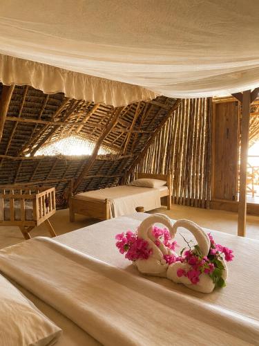 a room with two beds with flowers on top of it at Kita Ocean House in Kiwengwa