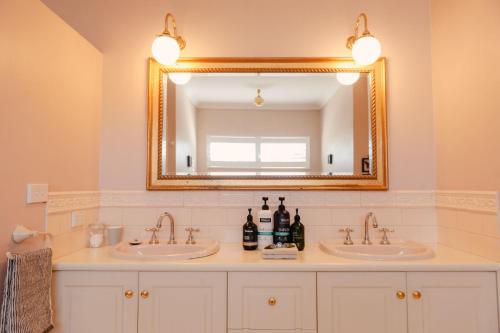 a bathroom with two sinks and a mirror at Lanterns Retreat in Dunsborough
