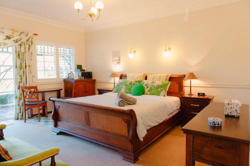 a bedroom with a bed with a desk and a chair at Lanterns Retreat in Dunsborough