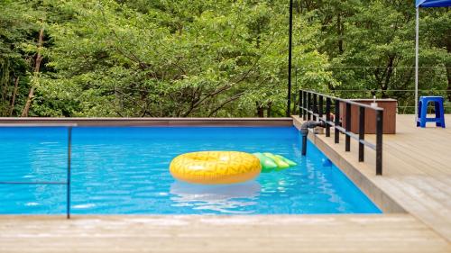 a swimming pool with a raft in the water at Mungyeong Between Mountains Pet Pension in Mungyeong