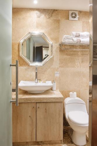 a bathroom with a sink and a toilet and a mirror at Chanka Suites in Talavera