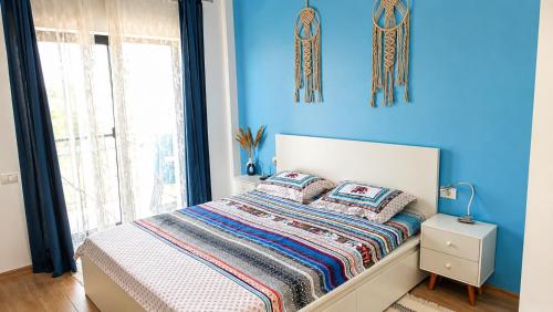 a bedroom with blue walls and a bed with pillows at Sea Ray Studio in Năvodari