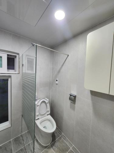 a bathroom with a toilet and a glass shower stall at Hanok Stay Ohneul in Gyeongju