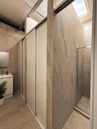 a walk in shower in a bathroom with a glass door at Brunsi Hostel in Melbourne